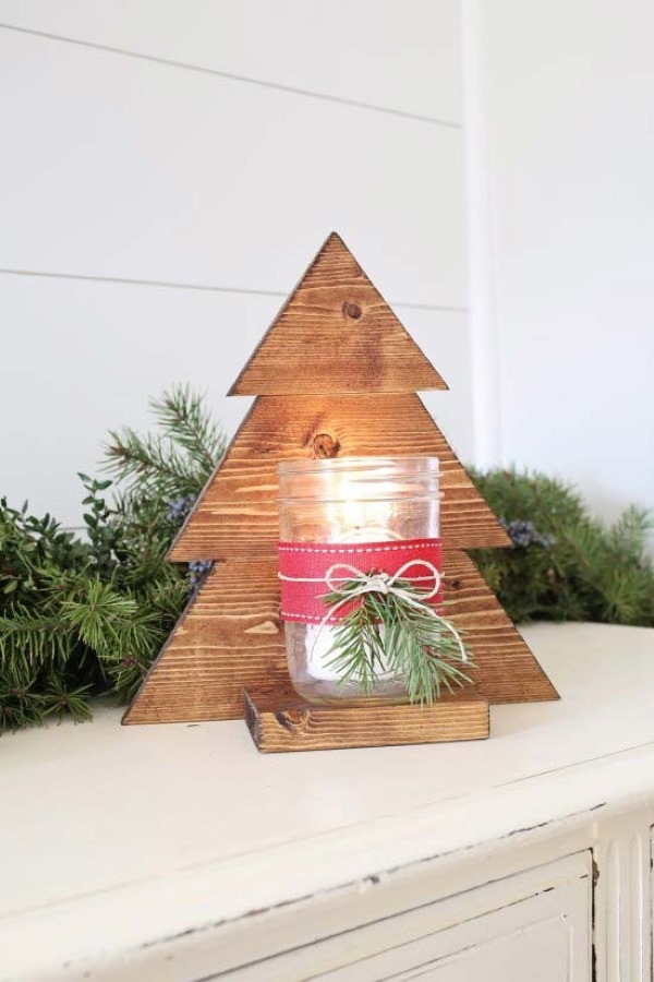 wooden christmas tree display with mason jar candle attachment on top of fireplace