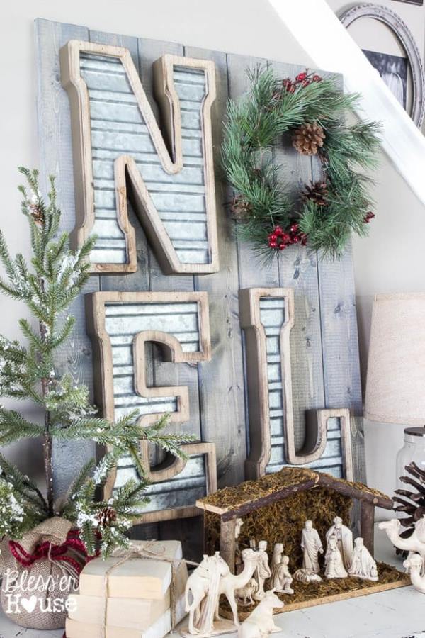 wood and tin noel sign with wreath and other christmas decor accents