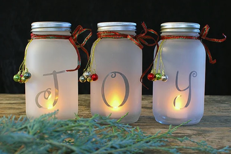 3 mason jars with votives in them that spell "JOY"