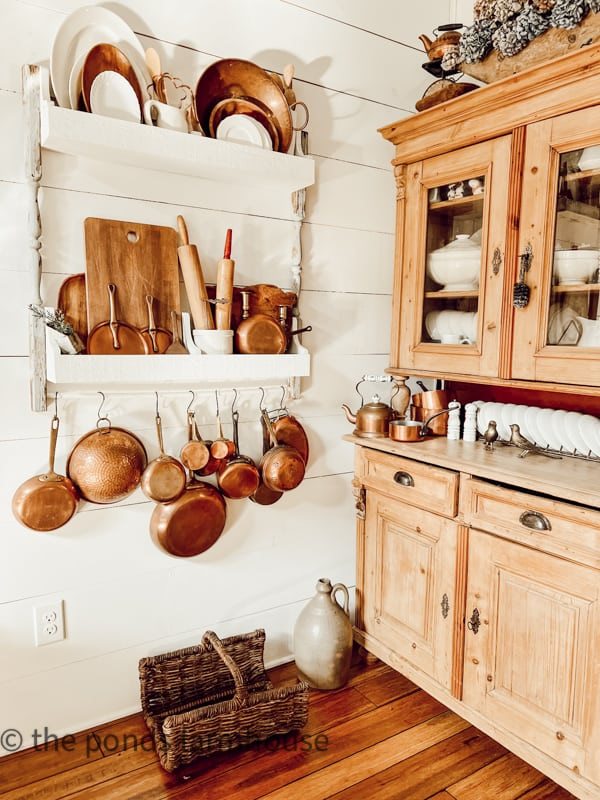 Copper Hanging Dishes and Pan Set Up in White Kitchen with Wood Canbinets