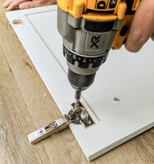 Handheld Drill Screwing in Hardware for Cabinet Door