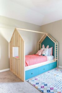 kids bed frame shaped like a cabin with open sides and storage underneath