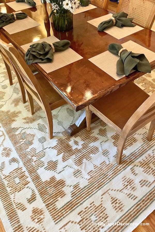 a close up of our new dining rug with the table and decor 